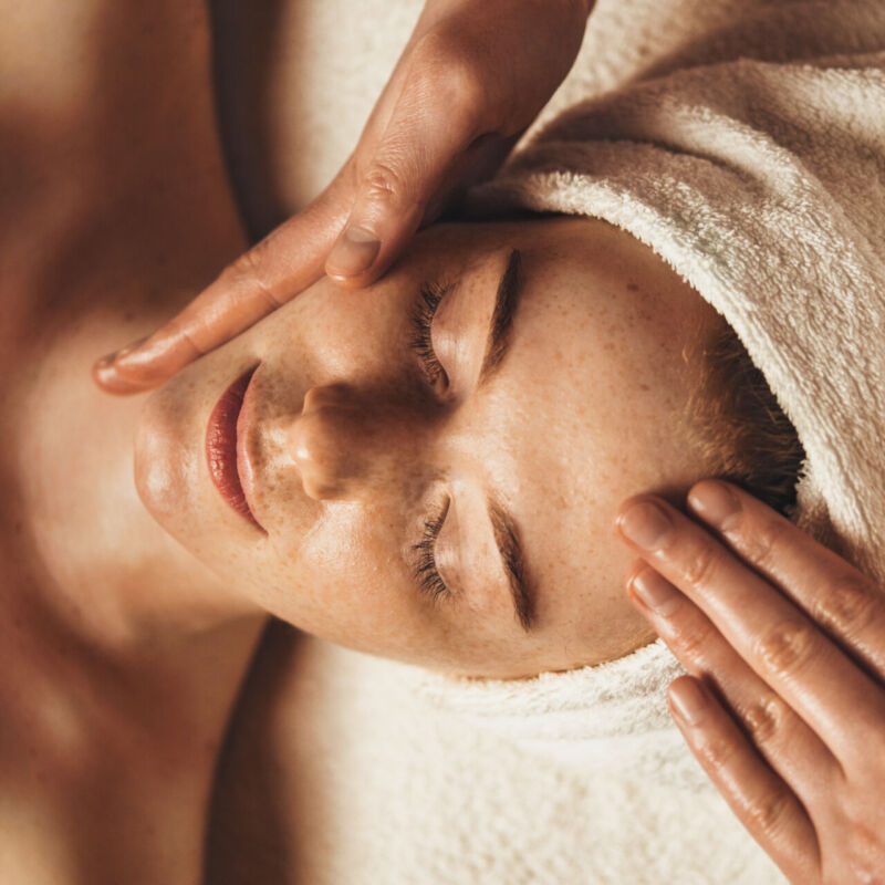 Close-up of young woman getting spa massage treatment at beauty spa salon. Cosmetology beauty skin care anti-aging treatment rejuvenation. Body care, spa. Facial beauty. Woman beauty face. Healthy lifestyle.